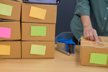 İşyerinde karton kutu ambalaj başlangıç küçük işletme sahibi. serbest kadın girişimci satıcı ürün parsel kutusu müşteriye teslim için hazırlayın. Online satış, e-ticaret kavramı