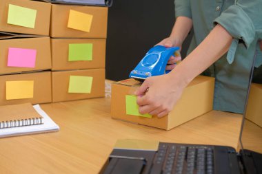 İşyerinde karton kutu ambalaj başlangıç küçük işletme sahibi. serbest kadın girişimci satıcı parsel kutusu, ürünün müşteriye teslim için hazırlayın. Online satış, e-ticaret kavramı