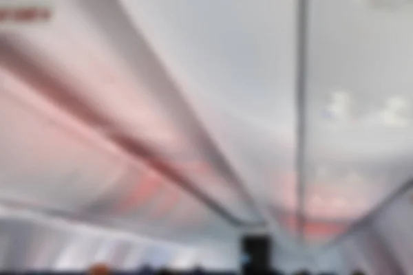 overhead baggage compartment in airplane. aircraft cabin interior. blurry defocused background