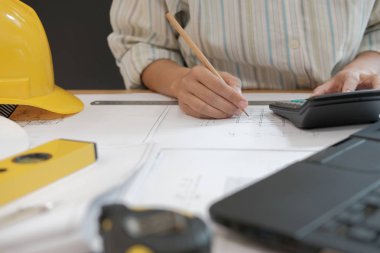 ev planı işyerinde gayrimenkul projesinin üzerinde çalışmaya mimar. Hesap makinesini kullanarak mühendis. Yapı ve inşaat kavramı