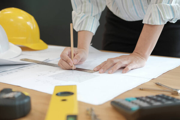 architect engineer working on house blueprint of real estate project at workplace. construction & building concept