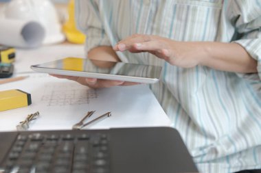 mimar tablet kullanma. gayrimenkul projesi ev planı üzerinde işyerinde çalışan mühendis. İnşaat ve yapı kavramı