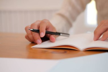 defter üzerinde evde krem kazak yazma Not giyen adam