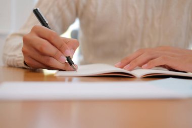defter üzerinde evde krem kazak yazma Not giyen adam