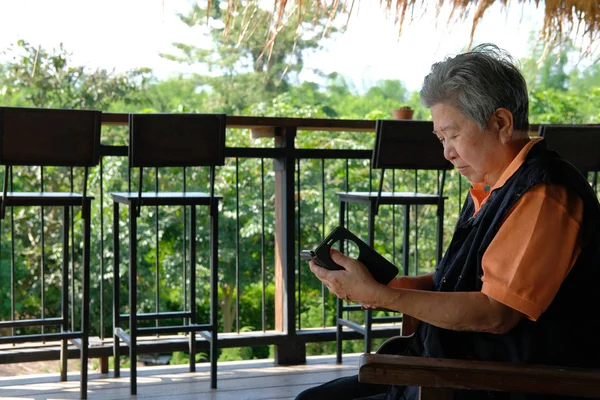 亚洲老年妇女拿着手机在露台上 老年女性老年使用智能手机在天井 — 图库照片