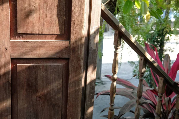 sunlight on weathered wooden door near stairs