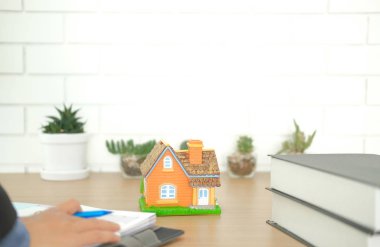 Emlakçı emlak planı ev modeli ile masa üzerinde düzenleme. Satış ve Kiralama Emlak