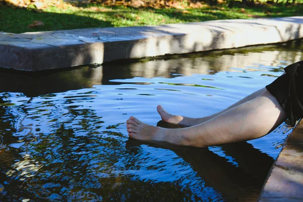 woman soaking feet in hot mineral spring water. healthy lifestyle & leisure activity
