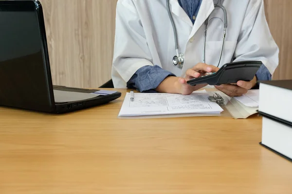 Doktor Doktor stetoskop ile tıbbi ücret maliyeti ve gelir hesaplamak. Uygulayıcı klinik hastanede hesap makinesi kullanın.