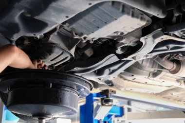 Araç basma tarafından hidrolik motor yağı değişimi ve iletim Denetim için. Otomobil tamir servisi değişen motor yağı. bakım ve Sağlık Araba Atölye kontrolü.