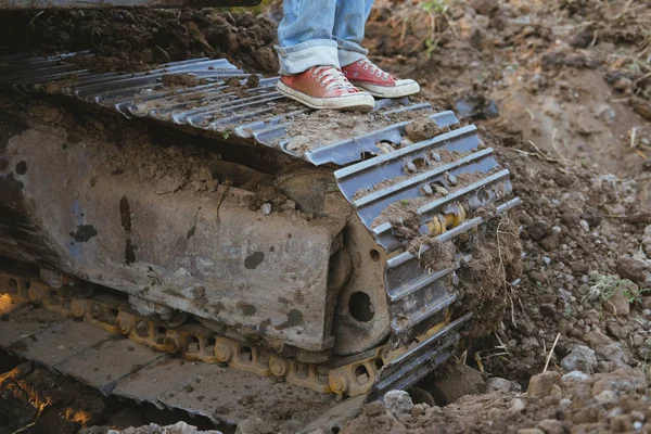 Worker feet wearing sneaker on excavator. man on backhoe — Stock Photo, Image