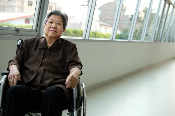 Elder woman in wheelchair resting near window. elderly female re — Stock Photo, Image