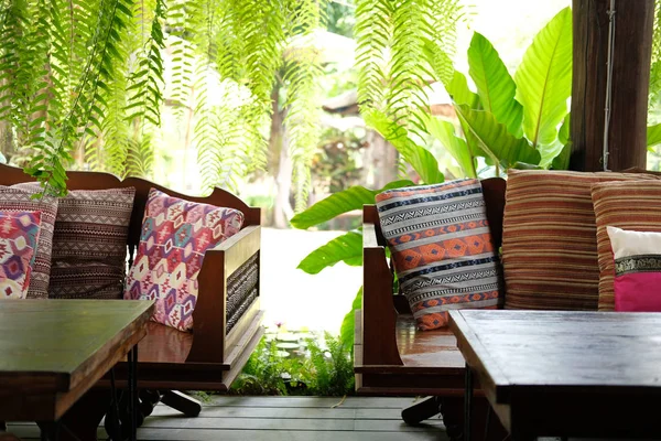 靠近花园的露台天井上的木制坐椅上的枕头 — 图库照片