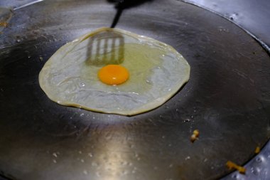 sıcak tavada roti üzerinde yumurta kızartma. Tayland'da geleneksel gıda 