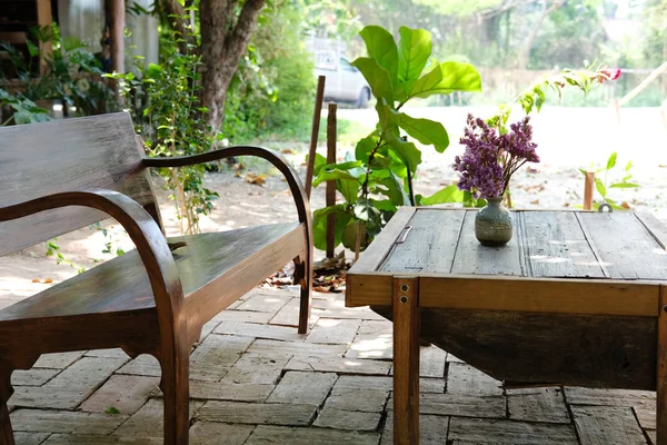 Flor em vaso na mesa de café de madeira no jardim — Fotografia de Stock