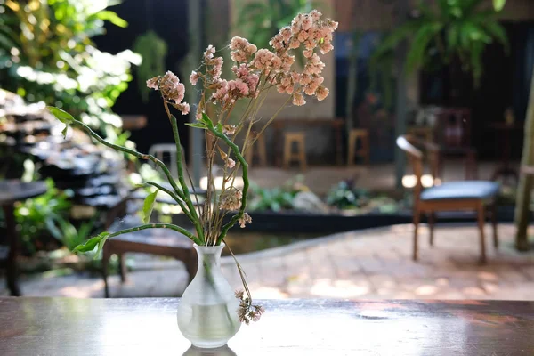 Kwiat w wazonie na drewnianym stoliku kawowym w ogrodzie — Zdjęcie stockowe