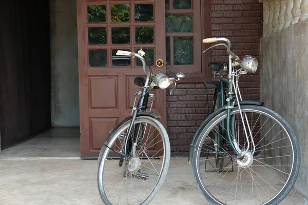 Bicicleta vintage estacionada na frente da porta marrom da casa — Fotografia de Stock