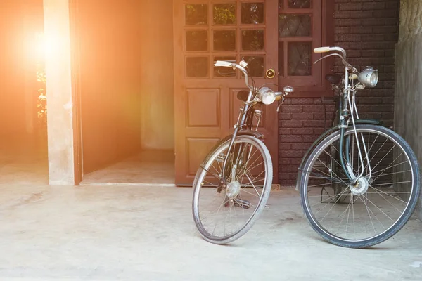 Bicicleta vintage estacionada na frente da porta marrom da casa — Fotografia de Stock