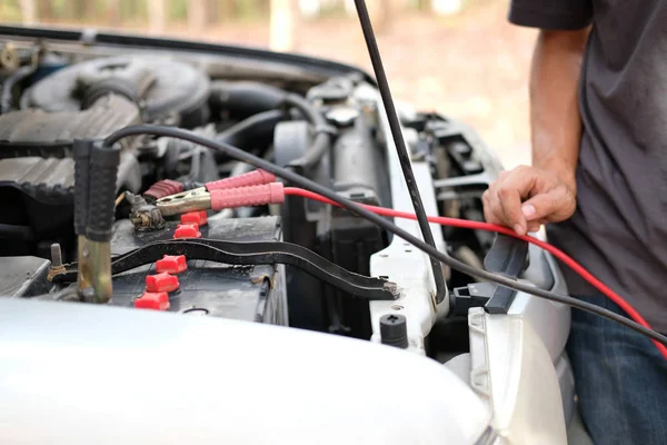 Monteur gebruik jumper kabels om de batterij van de dode auto op te laden — Stockfoto