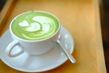 ahşap masada sıcak matcha yeşil çay latte. 
