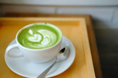 ahşap masada sıcak matcha yeşil çay latte. 