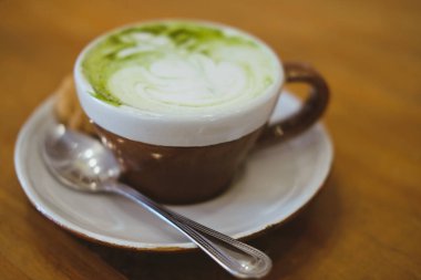 ahşap masada sıcak matcha yeşil çay latte. 