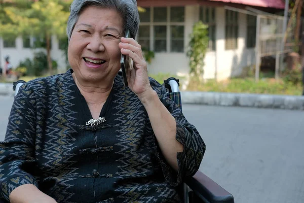 Mujer mayor en silla de ruedas hablar en el teléfono móvil. ancianos mayores s — Foto de Stock