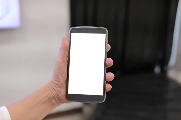 hand holding mobile smart phone at airport