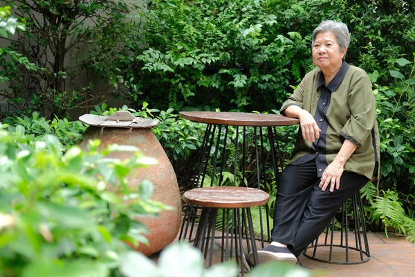 Una anciana descansando en el parque. anciana mujer relajante al aire libre — Foto de Stock