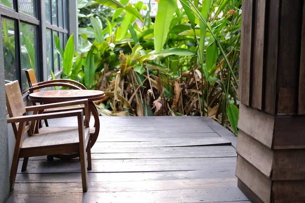 Mesa de madera y silla en la terraza cerca del jardín — Foto de Stock