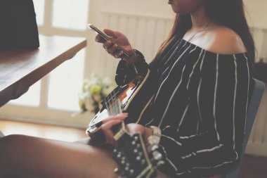 mobil akıllı telefon kullanarak gitar oynayan kadın