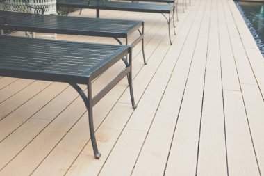 Yüzme havuzunun kenarında metal güneşlenme yatağı