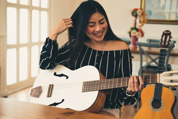 Uma mulher a tocar guitarra. conceito de estilo de vida lazer — Fotografia de Stock