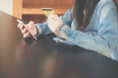 kadın alışveriş için cep telefonu kullanarak kredi kartı tutan o