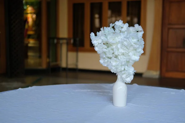 Bílá falešná květina na stole dekorace — Stock fotografie