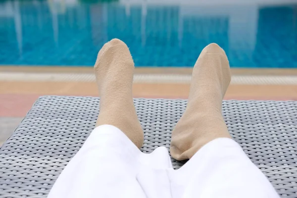 woman feet resting relaxing beside swimming pool.