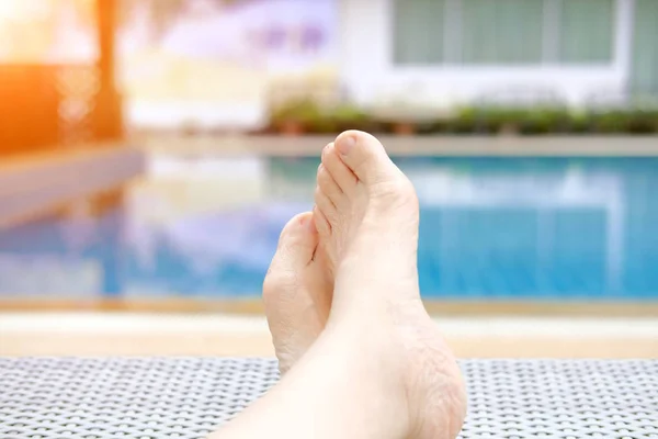 Femme pieds reposant relaxant au bord de la piscine . — Photo