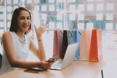 Shopp ile çevrimiçi ödeme için bilgisayar ve kredi kartı kullanan kadın