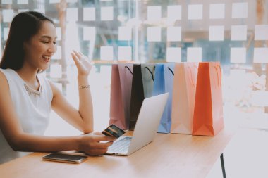 Shopp ile çevrimiçi ödeme için bilgisayar ve kredi kartı kullanan kadın