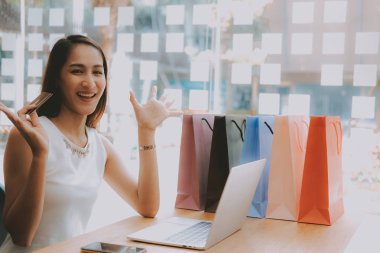 Shopp ile çevrimiçi ödeme için bilgisayar ve kredi kartı kullanan kadın