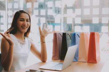 Shopp ile çevrimiçi ödeme için bilgisayar ve kredi kartı kullanan kadın