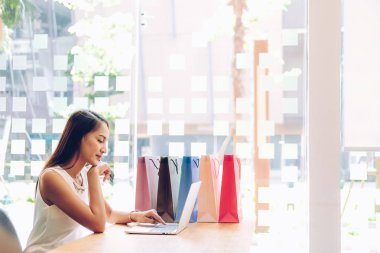 Shopp ile çevrimiçi ödeme için bilgisayar ve kredi kartı kullanan kadın