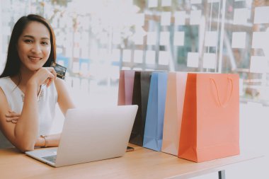 Shopp ile çevrimiçi ödeme için bilgisayar ve kredi kartı kullanan kadın