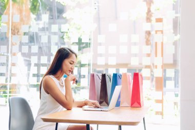 Shopp ile çevrimiçi ödeme için bilgisayar ve kredi kartı kullanan kadın