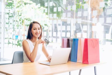 Shopp ile çevrimiçi ödeme için bilgisayar ve kredi kartı kullanan kadın