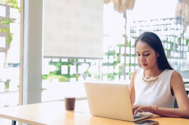 kafe kahve dükkanında bilgisayar kullanan asyalı kadın