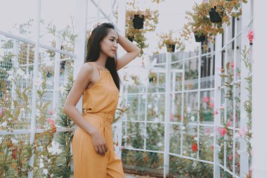 Çiçek bahçesinde dinlenen kadın yaz doğasının tadını çıkarıyor.