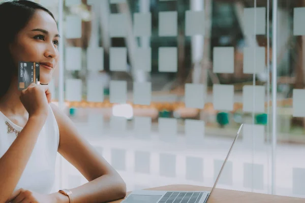 Женщина с помощью компьютера и кредитной карты для покупок в Интернете — стоковое фото