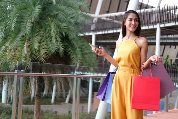 Mujer sosteniendo teléfono inteligente y bolsas de compras. consumismo estilo de vida — Foto de Stock