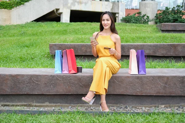 Mujer celebración de teléfono inteligente móvil y tarjeta de crédito para los pagadores en línea — Foto de Stock